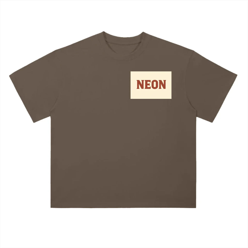 Brown oversized t-shirt with cream chest patch and bold red NEON text, classic American style